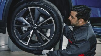 Nissan yetkili servisinde Qashqai bakımı yapılırken teknisyen jant ve lastik kontrolü yapıyor