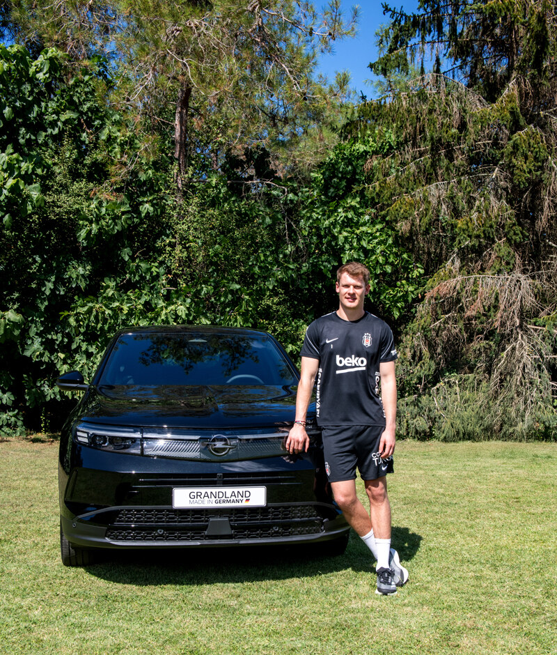 Beşiktaş JK oyuncusu Opel Grandland aracının önünde poz veriyor